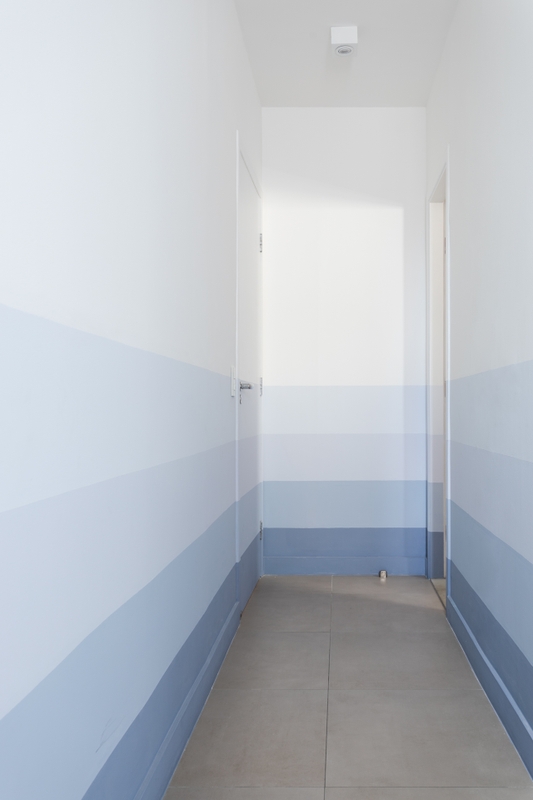 Parede do corredor com pintura degradê de listras azuis | Cores Chuva Gelada, Azul-Etéreo e Banho de Espuma Suvinil