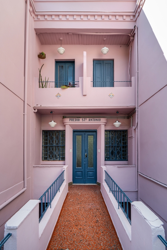 Prédio cor de rosa com janelas e portas azuis usando as cores Anoitecer e Meia-Luz Suvinil.