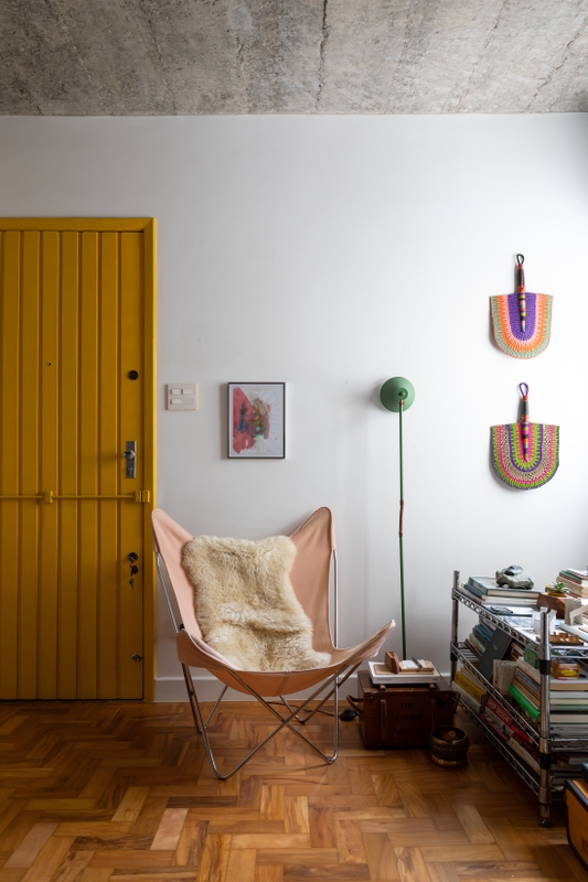 Sala de estar Integrada com porta amarela na cor Sol Nascente Suvinil e teto de concreto aparente | Foto de Lufe Gomes