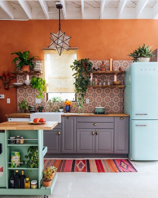 Cozinha Integrada com armários na cor cinza | Ilha e geladeira estão em um tom de azul claro | Paredes na cor Forró Suvinil