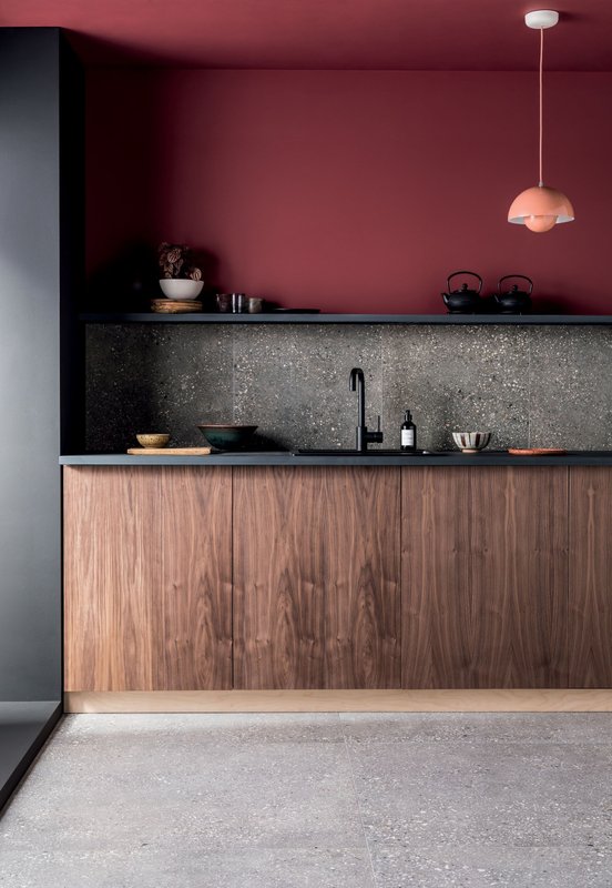 Cozinha Integrada com meia parede e chão em cimento queimado | Bancada de madeira escura | Parede na cor Desejo Suvinil
