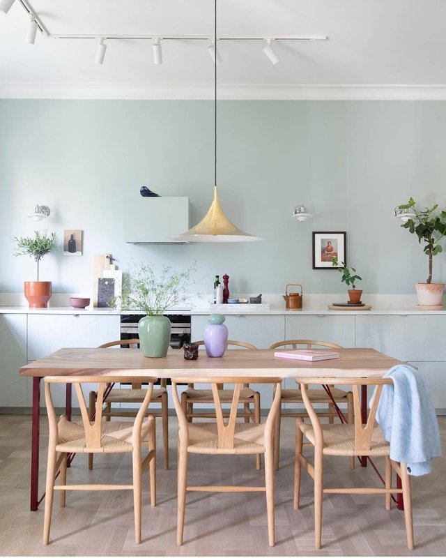 Cozinha com mesa de madeira clara no centro | Paredes na cor Água-Viva Suvinil | Objetos de decoração coloridos