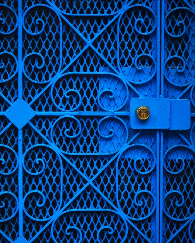 Portão de ferro na cor Caneta Azul Suvinil | Fechadura dourada | Varios detalhes no design como arcos, arabescos e losangos.