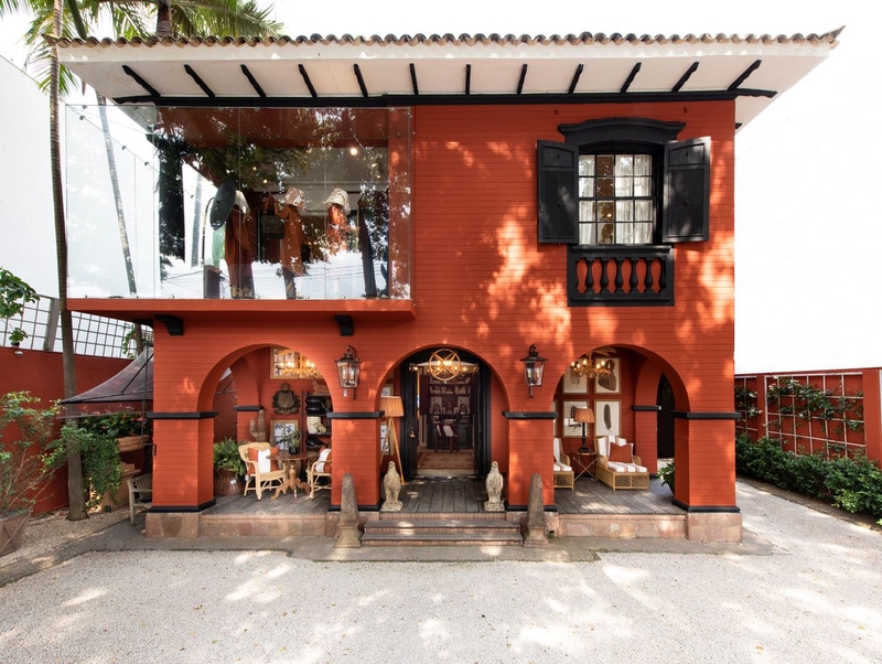frente de casa de Tijolos Terracota Suvinil | Arcos, deck de madeira, vitrine e janela antiga preta | Foto de Entreposto