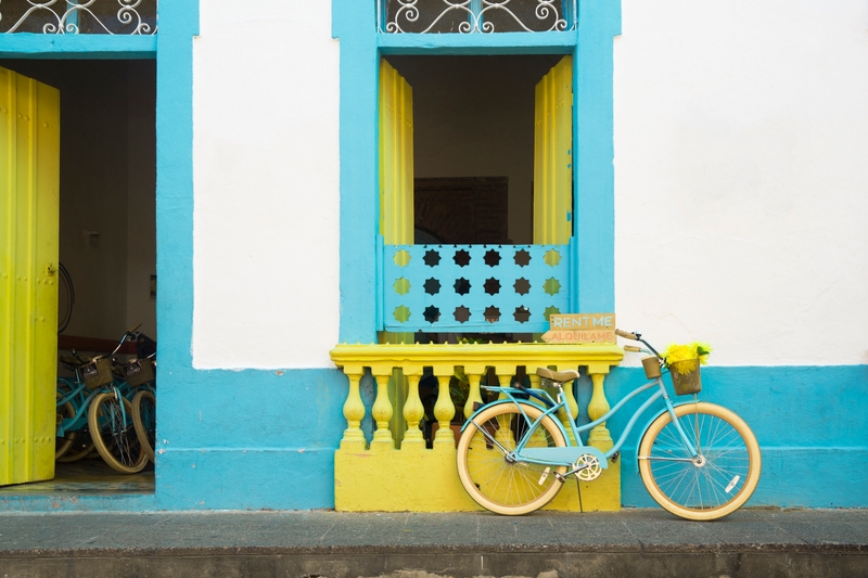 Fachada verde, azul e branca com bicicleta colorida | Cores Brisa Amena e Quentão Suvinil | Foto de John Burcham