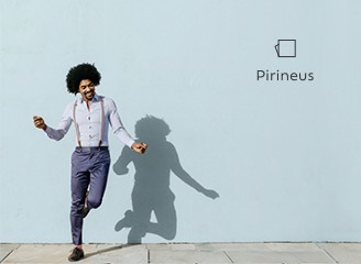 Homem dança alegremente em frente a uma parede com a cor azulada Pirineus propondo um convite a se abrir para novas cores